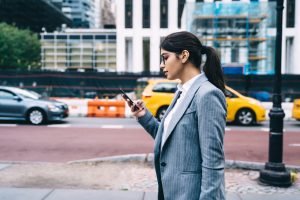 intelligent-female-employee-reading-mobile-news.jpg